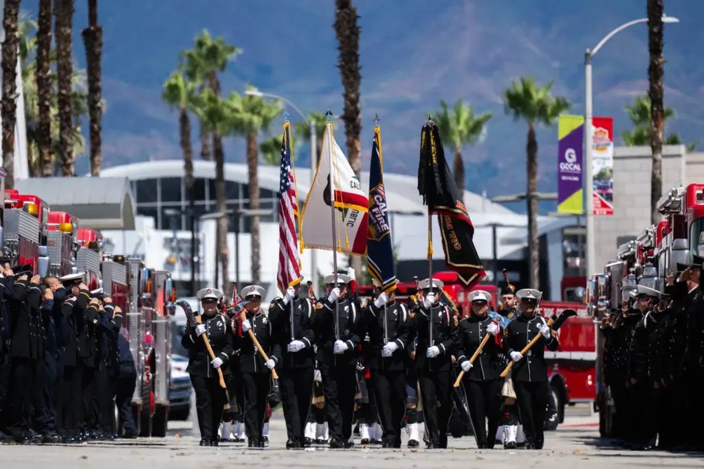 Members of the Cal Fire Honor Guard march solemnly during...