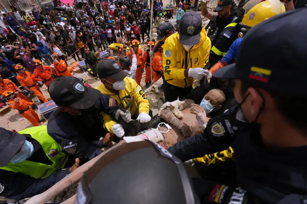 Rescue workers carry a man rescued from the rubble of...