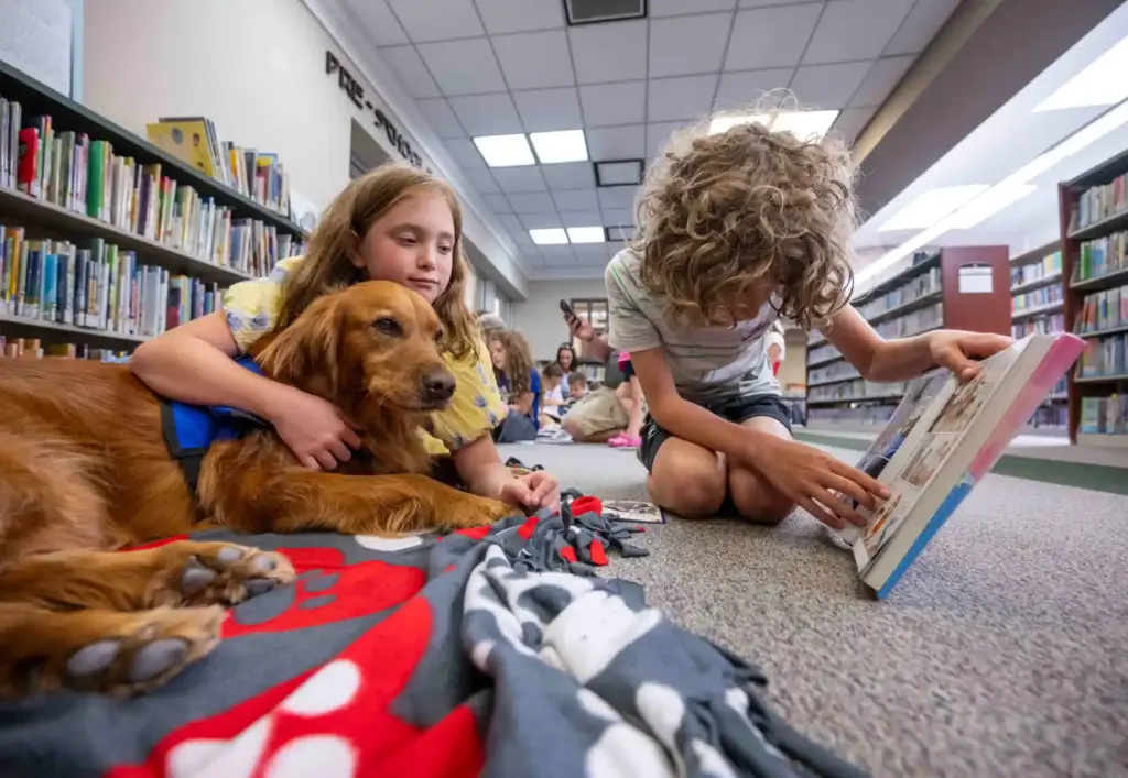 Logan Kalscheuer, 9, right, of Ladera Ranch, reads a childrenâs...