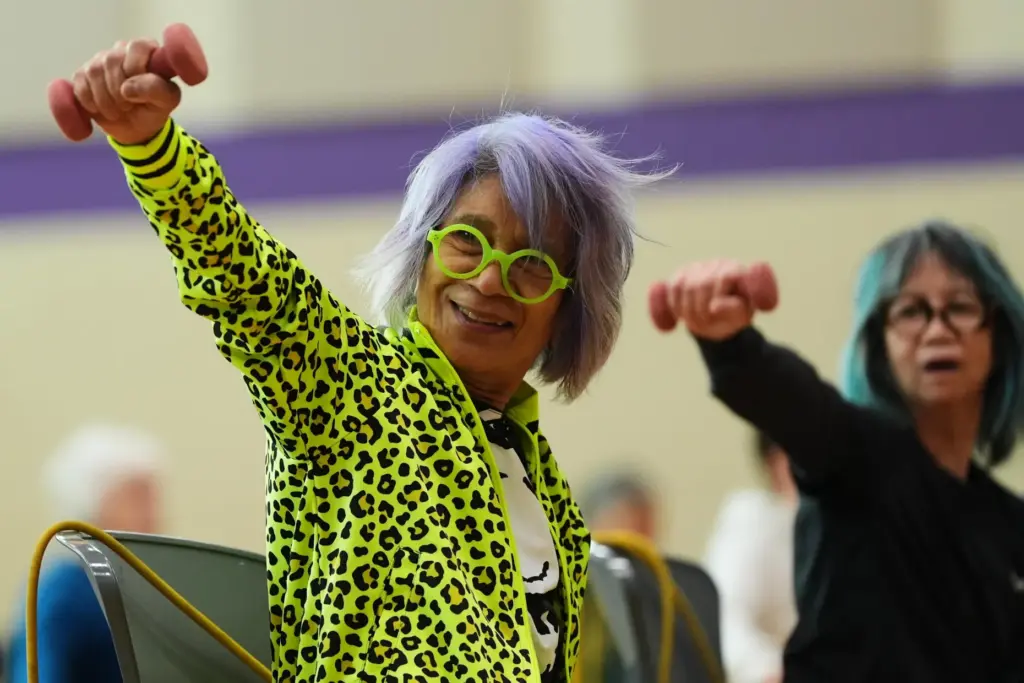 Lili Bonilla raises light weights during an exercise class for older adults.