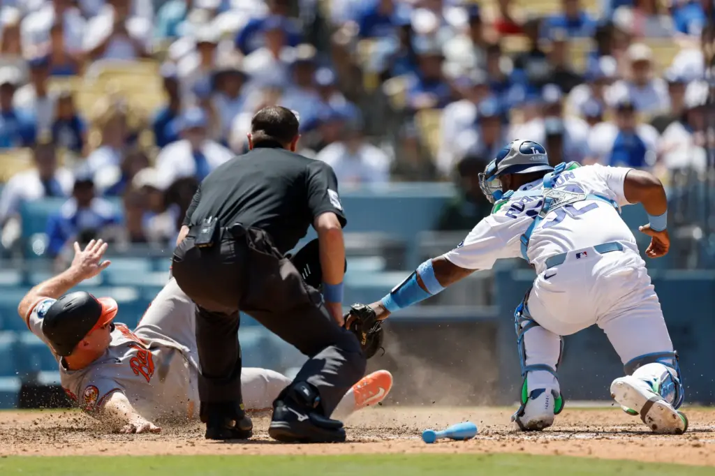 Dodgers catcher Chuckie Robinson, right, reaches to tag Baltimore Orioles’...