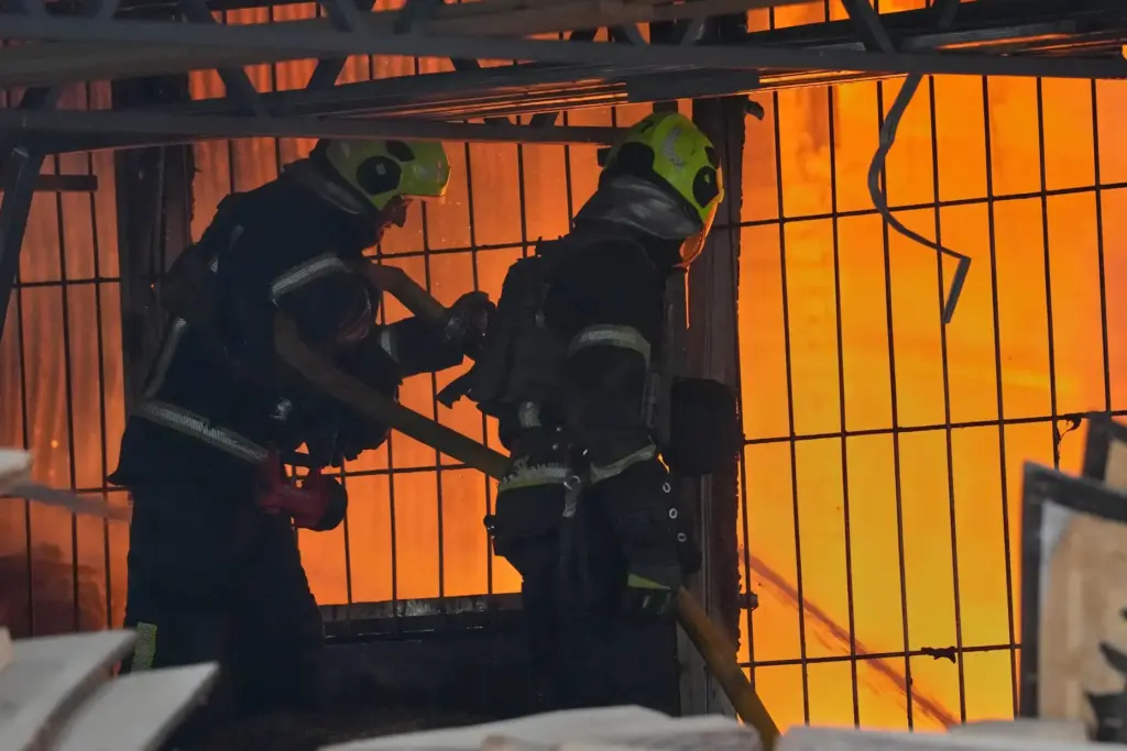 Firefighters work on the site of a burning building after a Russian missile attack.