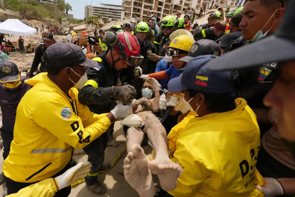 Relief workers carry a man rescued from a building that...