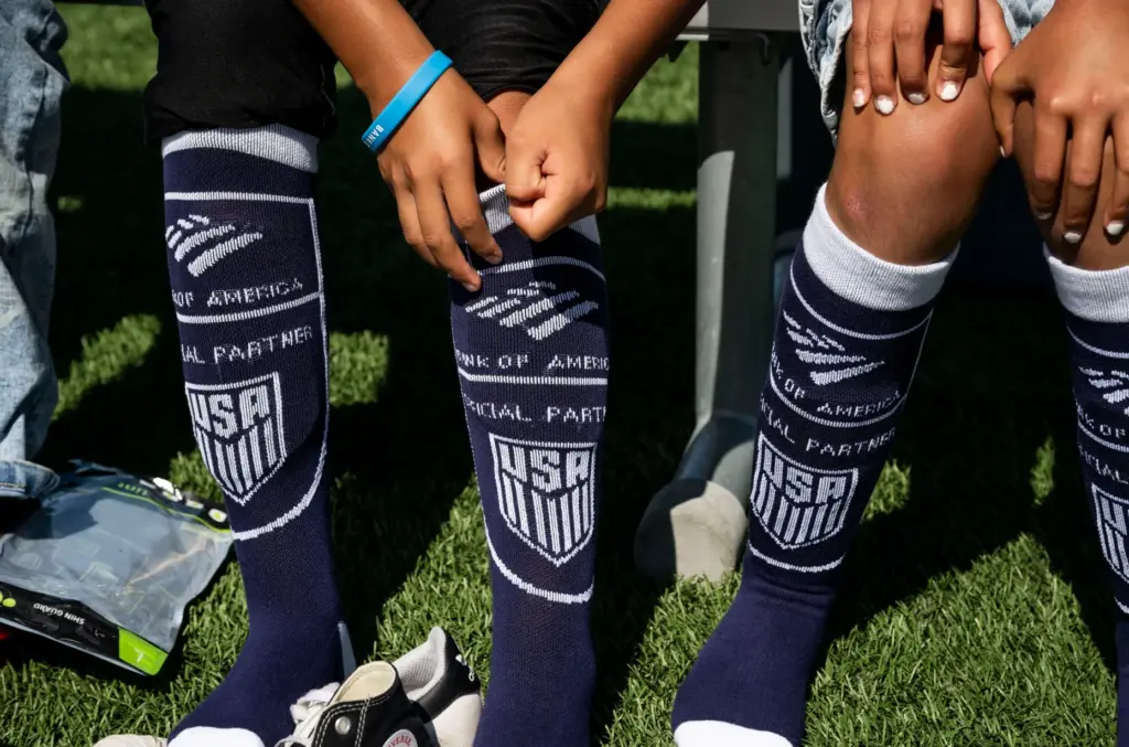 Kids put on their new socks and shin guards during...