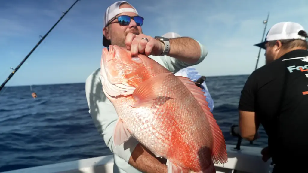 Chris Kemp holds up a red snapper he caught on...