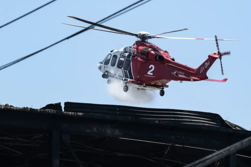 A helicopter makes a water drop on the Lineage warehouse...