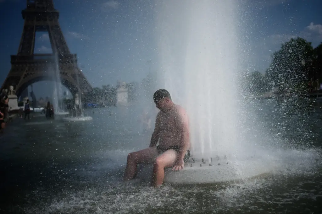 A person cools off at Trocadero fountain near the Eiffel Tower.