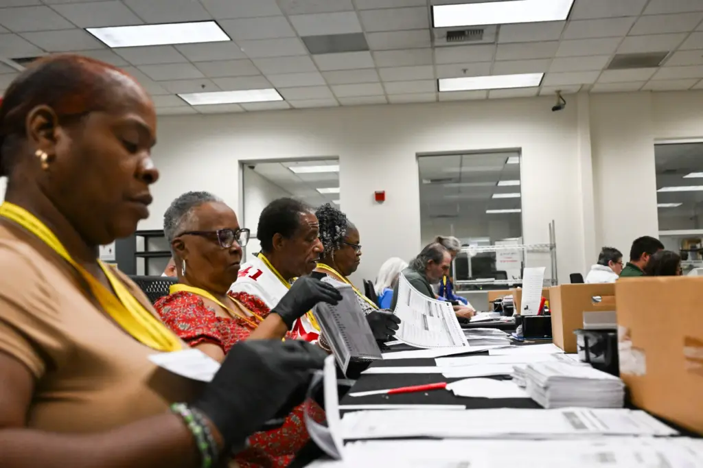 Temporary election assistants process vote-by-mail ballots Monday, June 1, 2026,...