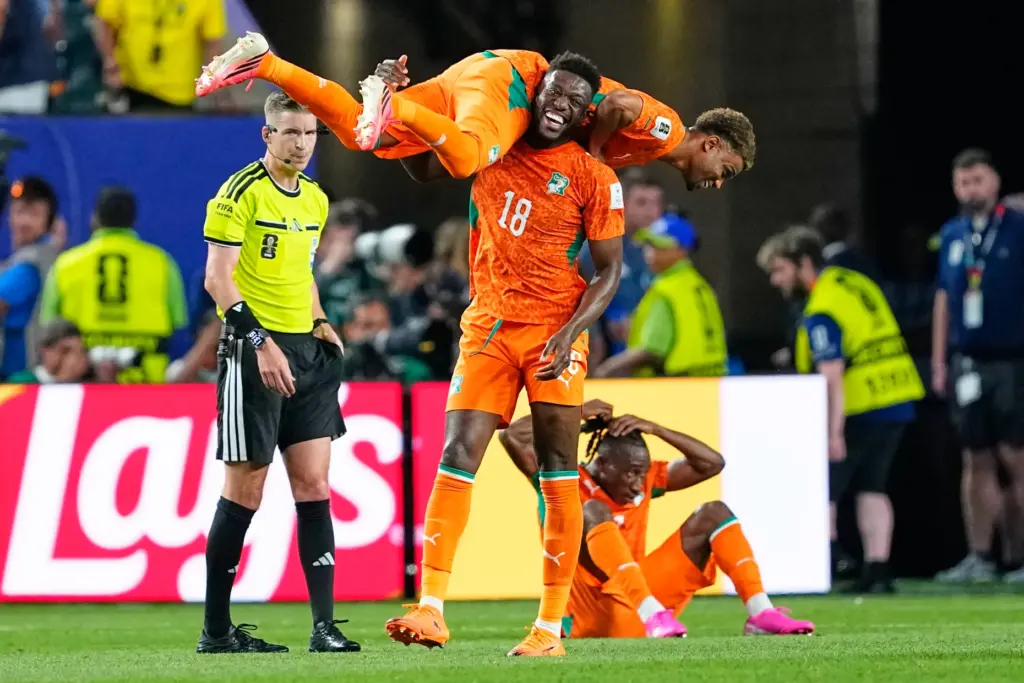 Ivory Coast’s Ibrahim Sangare (18) carries teammate Amad Diallo (15)...