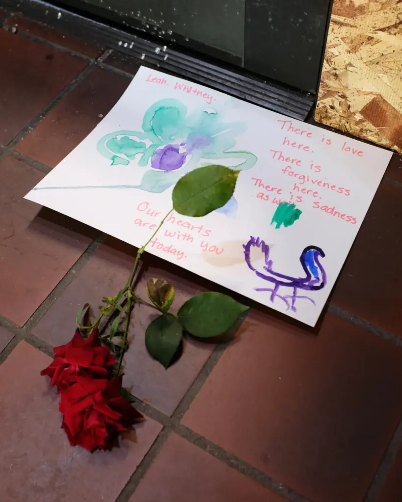 A condolence note and a pair of roses are laid...