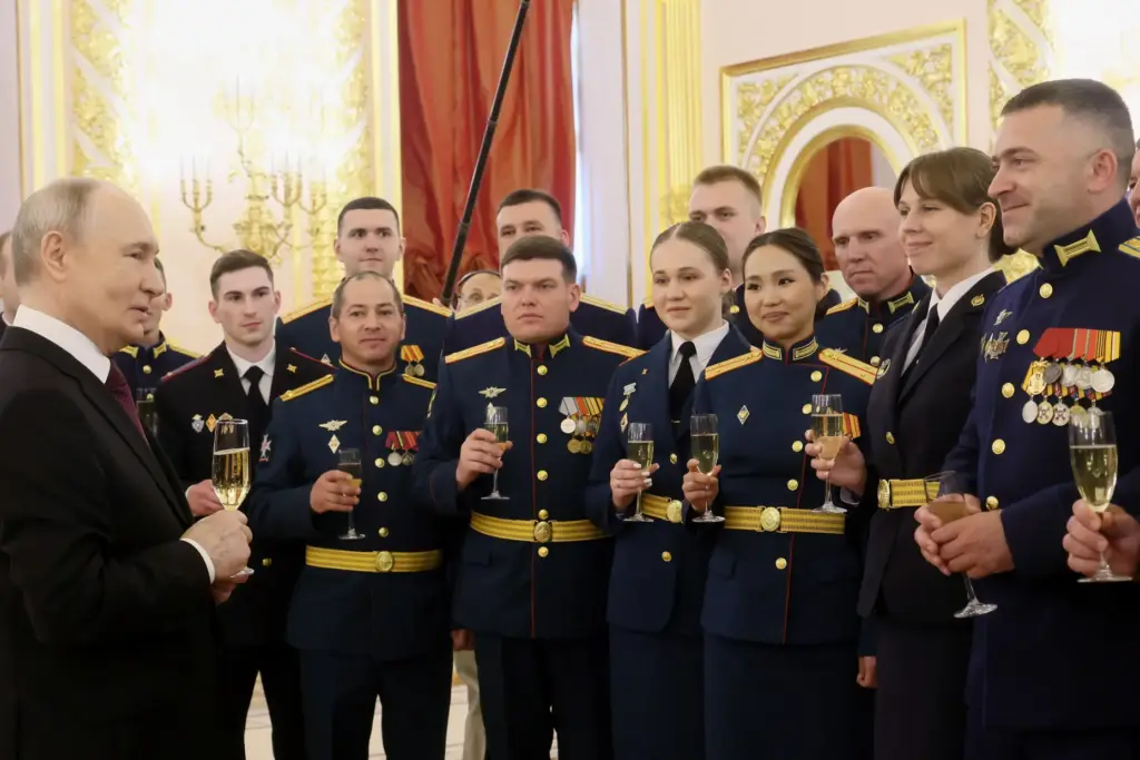 Russian President Vladimir Putin, left, toasts with graduates of the...