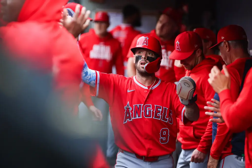 The Angels’ Zach Neto celebrates in the dugout after scoring...