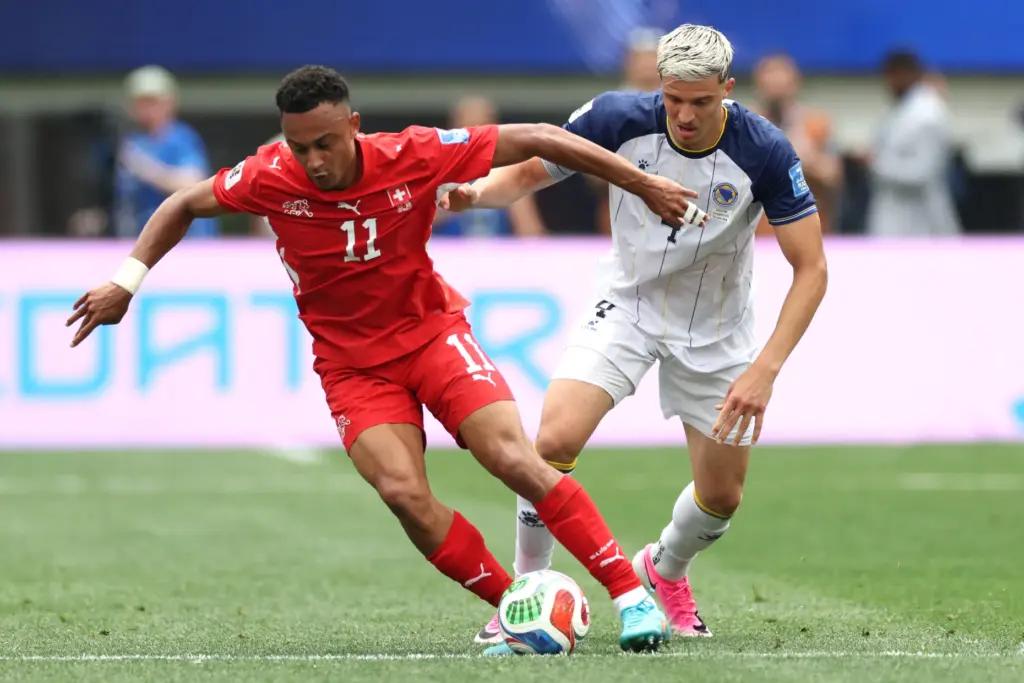 Switzerland forward Dan Ndoye (11) controls the ball defended by...