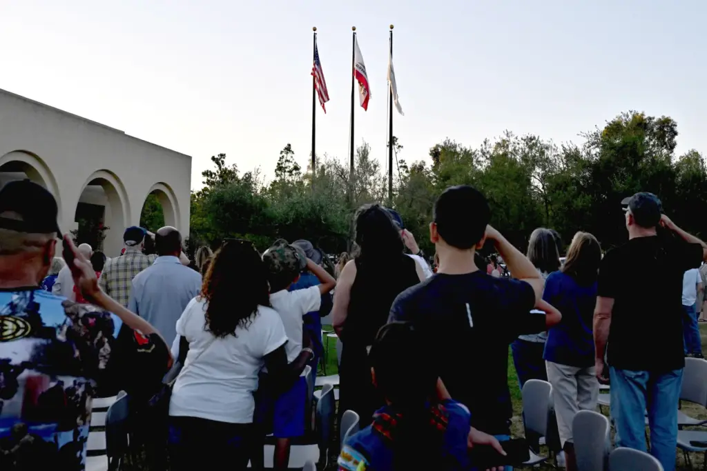 People salute during an American flag retirement ceremony in Rancho...