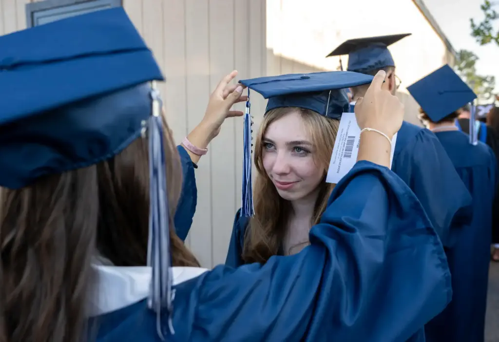 Jenna Miner, left, helps Jocelyn Miner, no relation, with her...