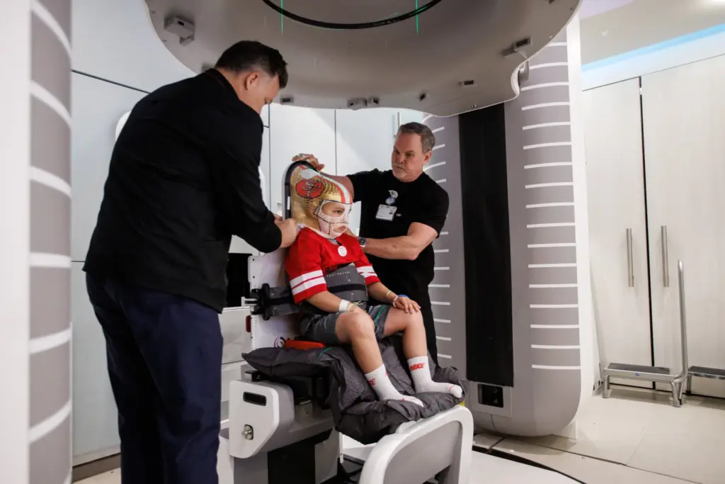 Patient Stephen De La Torre, 7, is fitted with a...