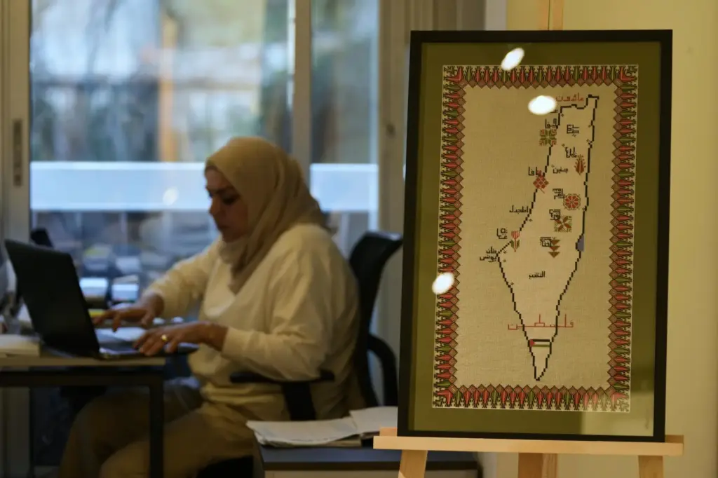 A hand-embroidered map of historic Palestine with names of cities...