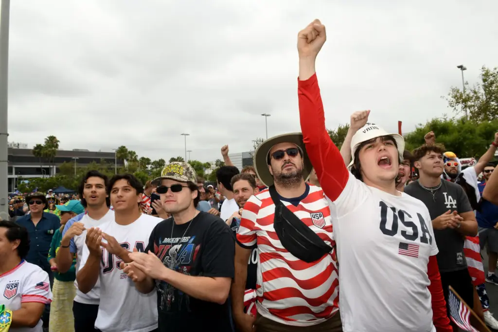 Levi Dokus and his friends cheer their team as the...