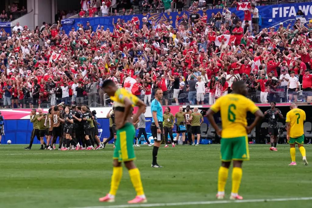 Canada’s players celebrate their team first goal against South Africa...