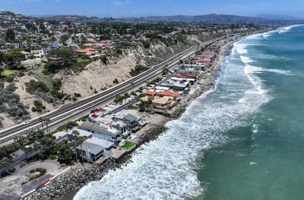 Waves hit the rocks below homes at Capistrano Beach in...
