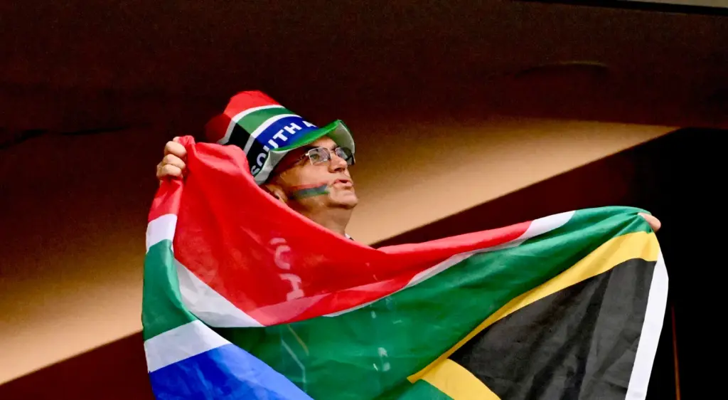 South African fan wearing a hat, waves his flag prior...