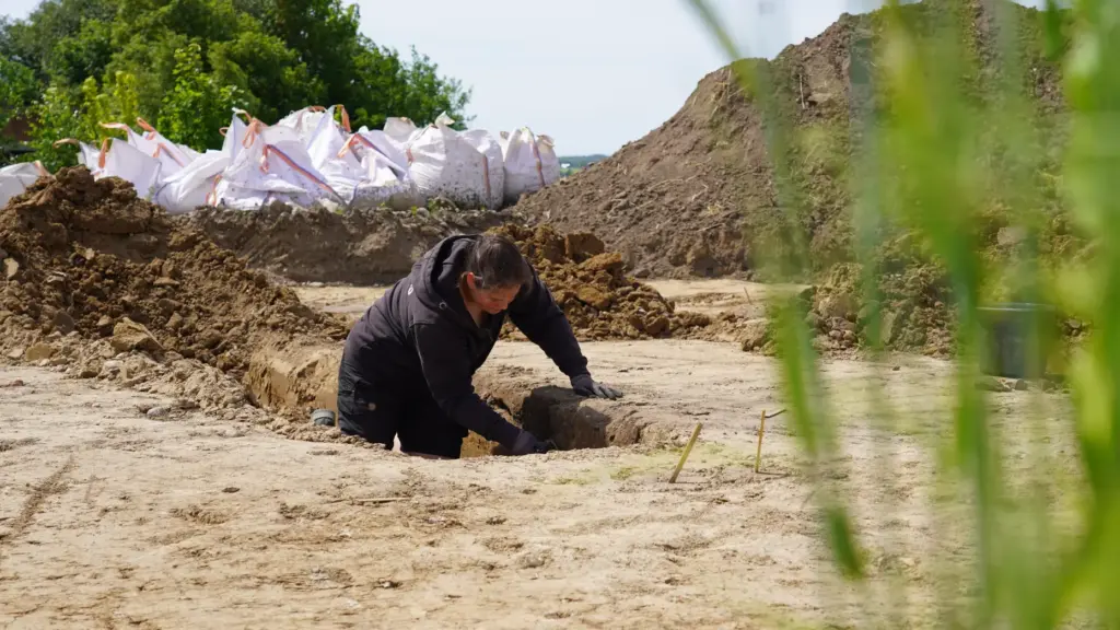 An archaeologists excavates a Viking Age pit house in Aarhus, Denmark.