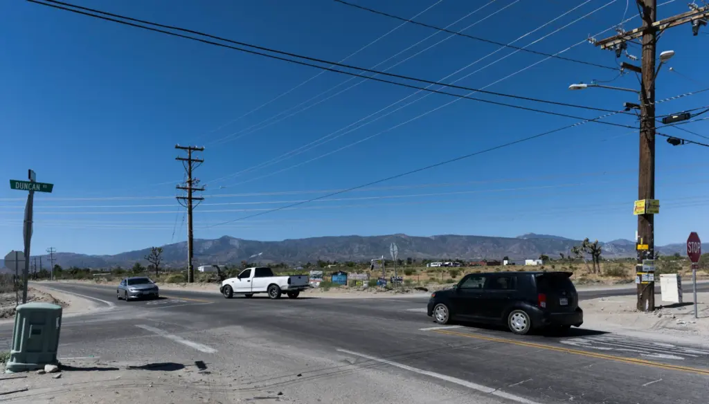 Cars drive along Sheep Creek Road, a short distance away...