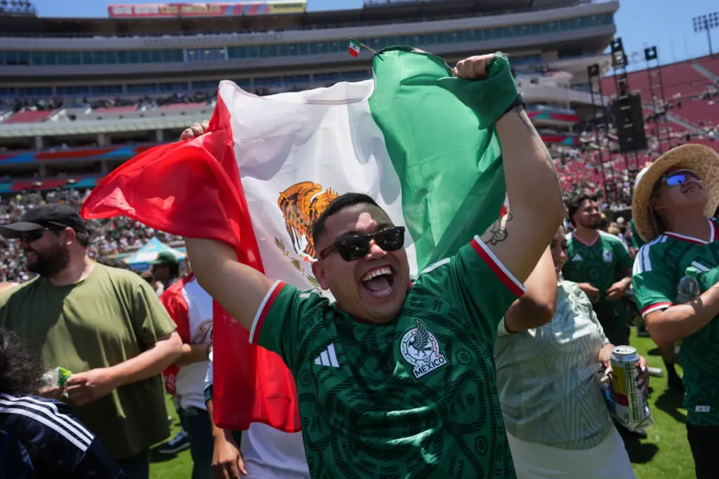 Fans celebrate a goal by Mexico while watching a live...