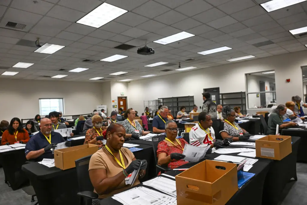 Temporary election assistants process vote-by-mail ballots Monday, June 1, 2026,...