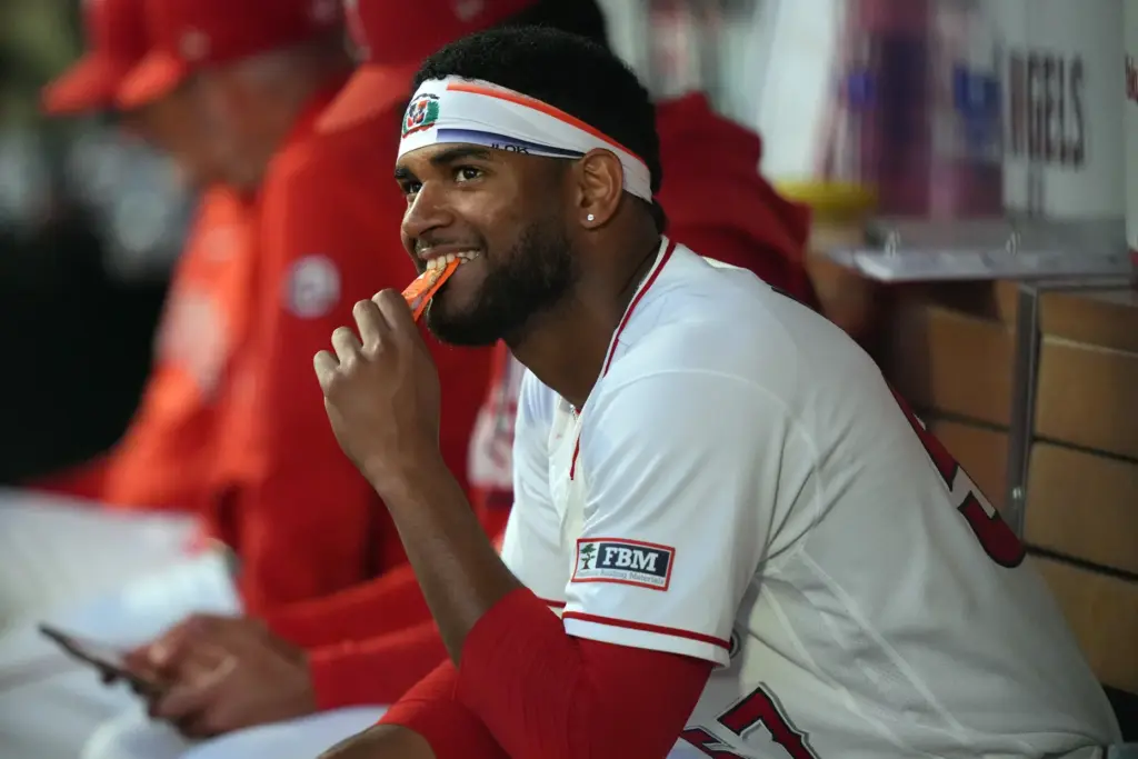 Angels starting pitcher Walbert Urena smiles in the dugout after...