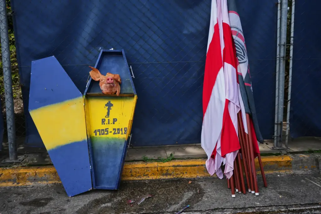 A cardboard coffin decorated with Boca Juniors' colors sits next to River Plate flags.