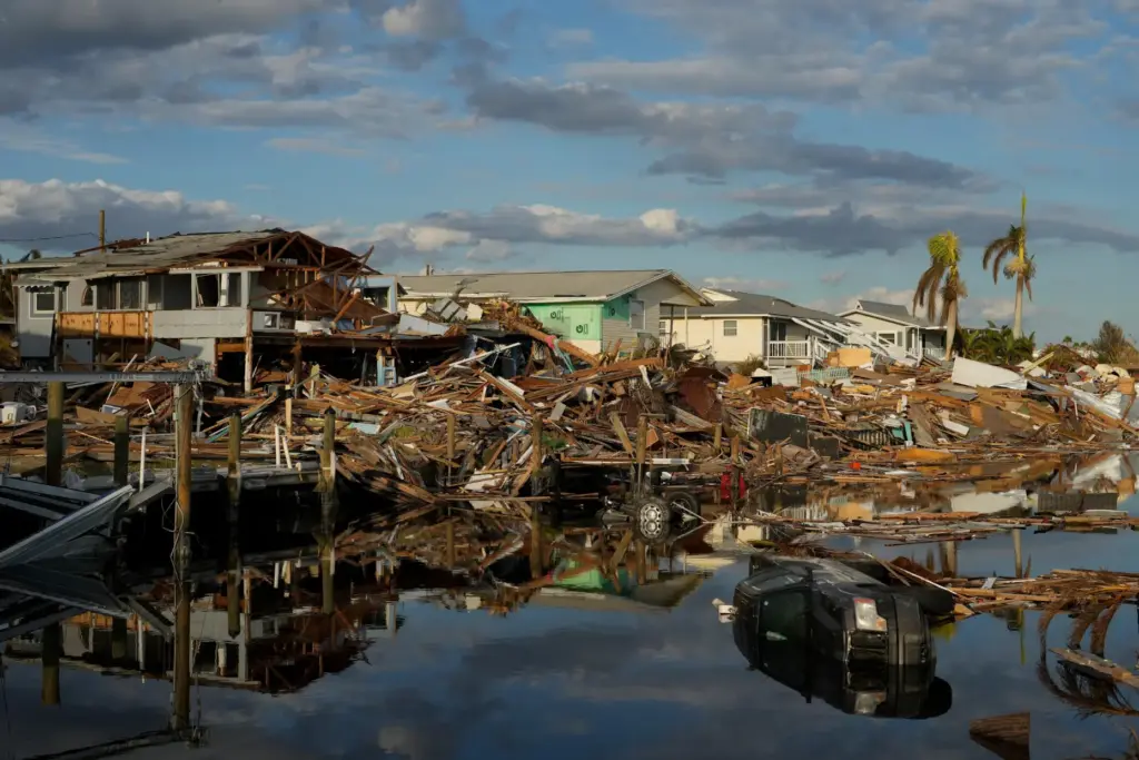 FILE – Cars and debris from washed away homes line...