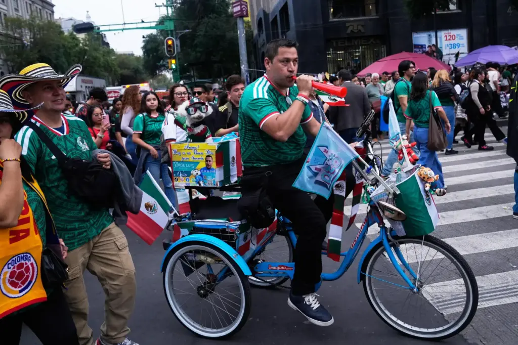 Jorge Rangel rides a bicycle accompanied by his dog, Osito,...