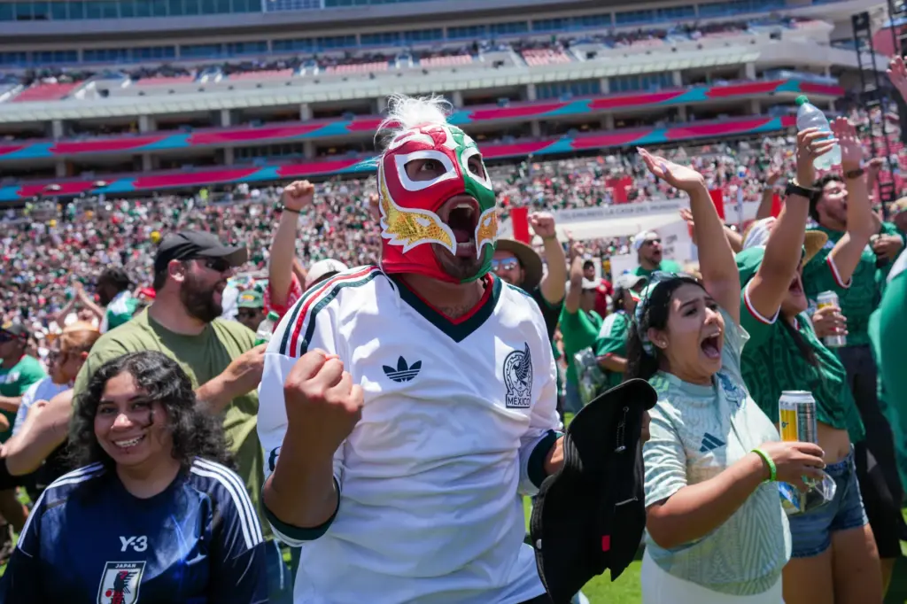 Fans celebrate a goal by Mexico while watching a live...