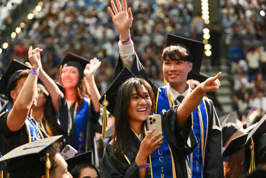 Graduates wave to family and friends during the commencement ceremony...
