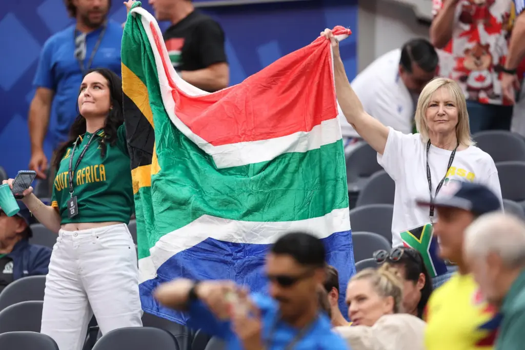 Two South Africa fans hold up a flag before the...