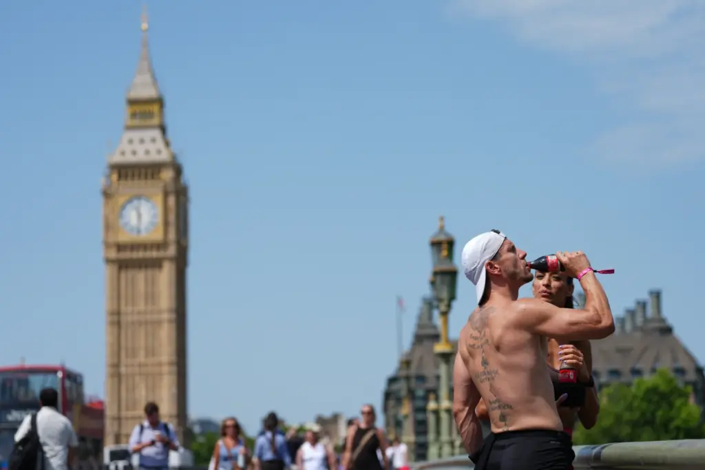 A man drinks on Westminster Bridge in London, as a...