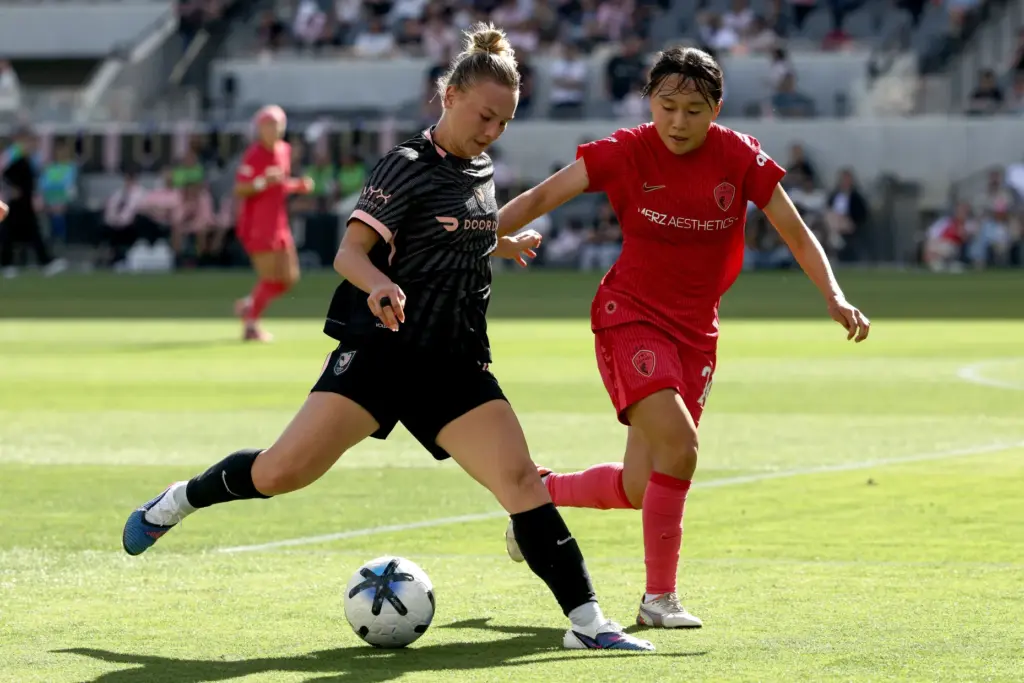 Angel City FC midfielder Kennedy Fuller, left, moves the ball...