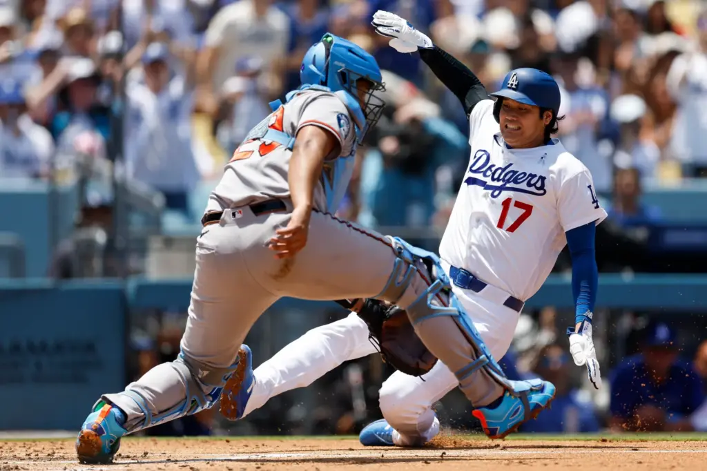 Dodgers designated hitter Shohei Ohtani (17) slides into home plate...