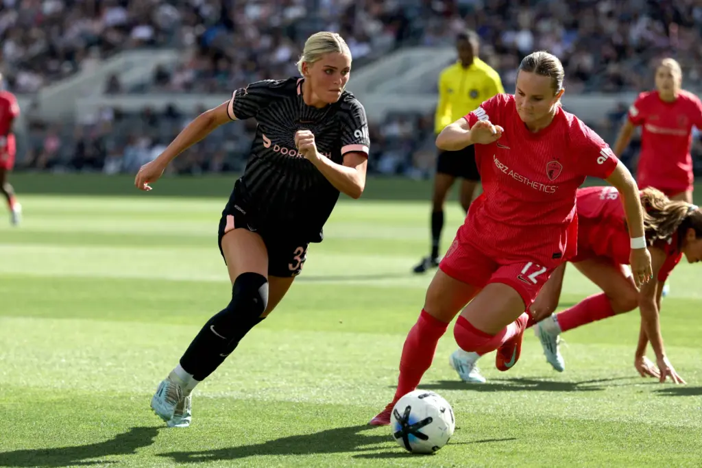 Angel City FC forward Riley Tiernan, left, brings the ball...