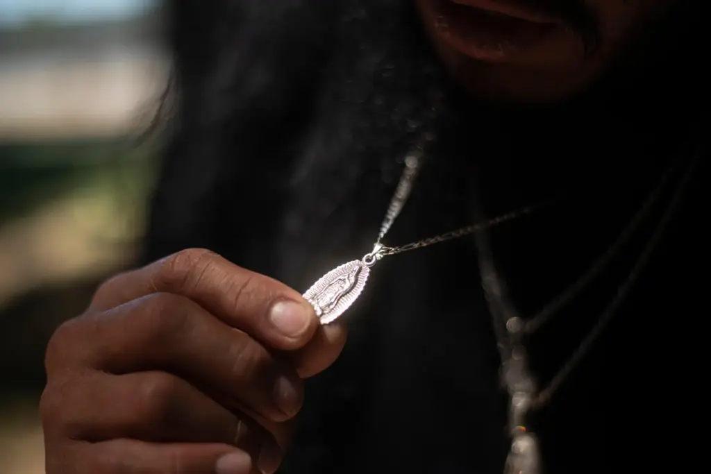 Gabriel Martinez Garcia, 30, holds a Hail Mary necklace given to him by his mother.