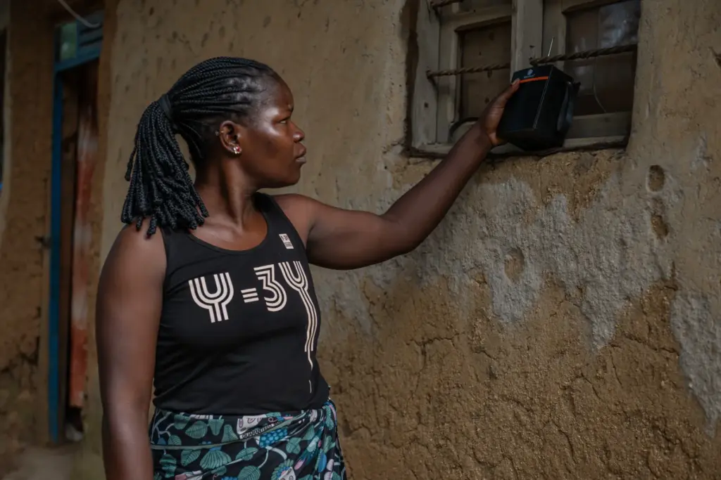 Chantie Joe Kiss listens to the radio for awareness and updates on Ebola in Bunia, Congo.