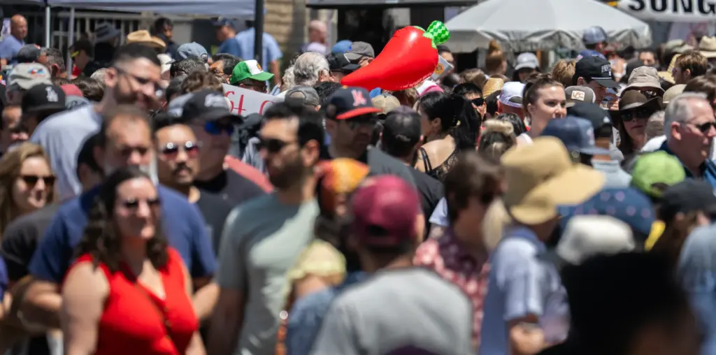 A bright red chili pepper mingles among the crowd during...