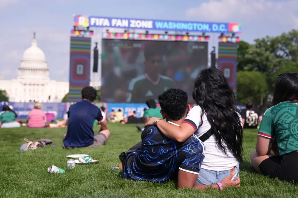 Fans watch the first match of the World Cup between...