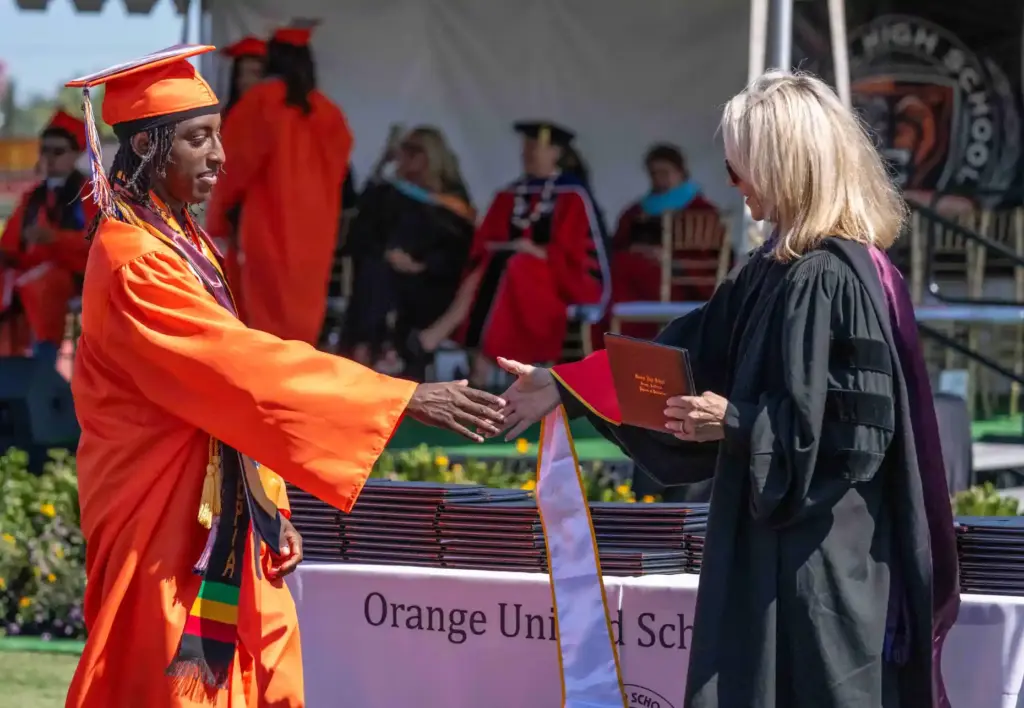 Kwali Williams accepts his diploma during Orange High Schoolâs graduation...