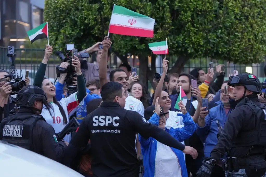 Fans for team Iran wave as players arrive for the World Cup.