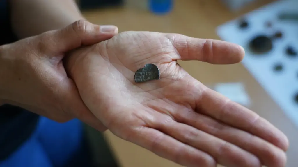 Moesgaard Museum archaeologist Liv Stidsing Reher-Langberg holds a Viking Age silver coin.