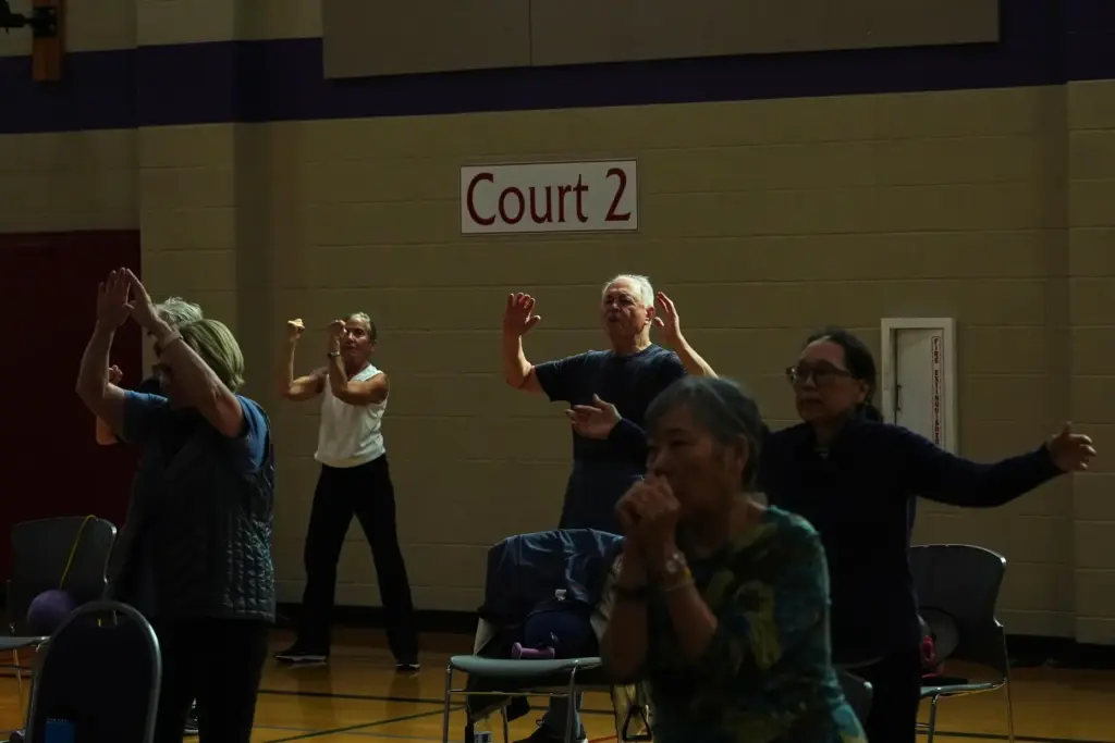 Participants do arm exercises in a class for older adults.