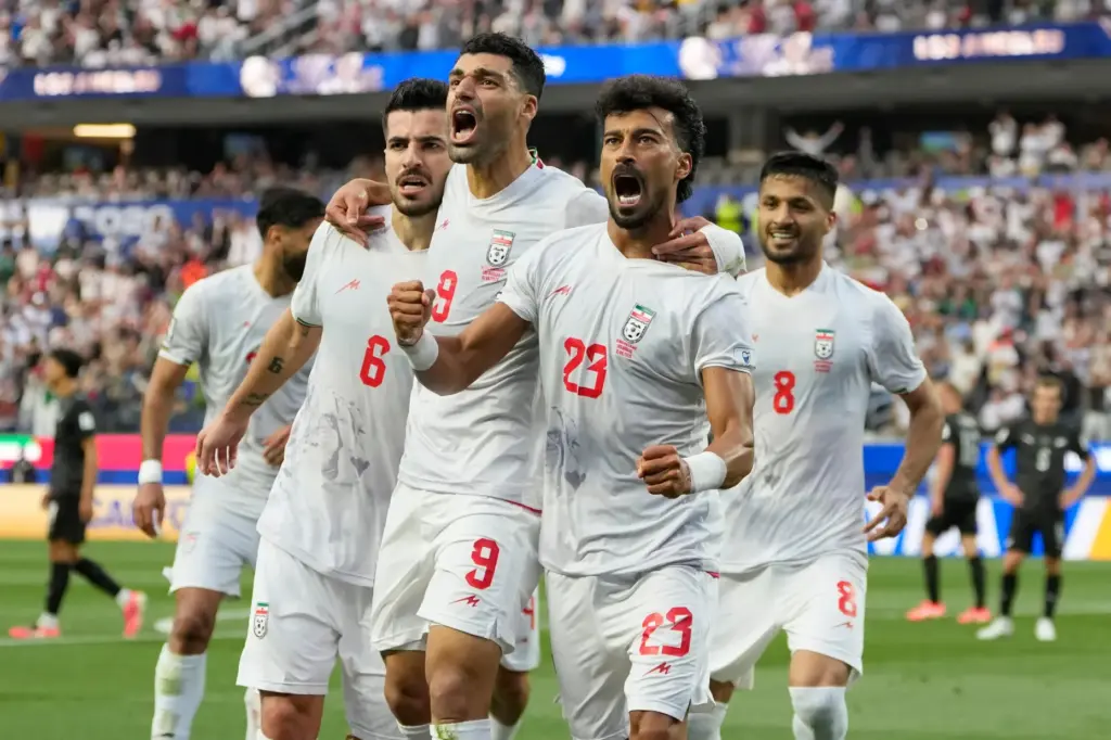 Iran’s Ramin Rezaeian (23) celebrates with his teammates after scoring...