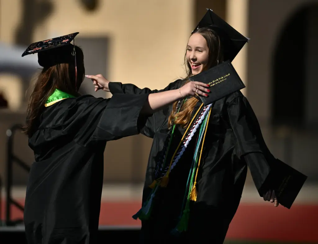 Kaylin Ganier, right, smiles as she gets a hug from...